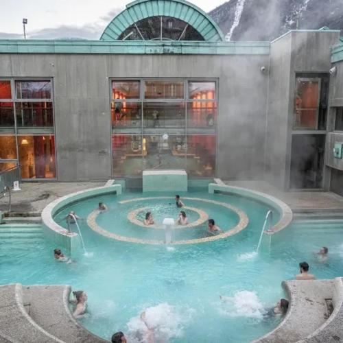 a pool in a building with people in the water at Le Chalet - Appartement 5 personnes avec parking in Savignac-les-Ormeaux