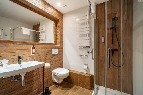 a bathroom with a toilet and a sink and a shower at Muselet Adults Only in Świnoujście