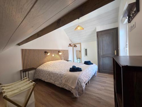 a bedroom with a bed and a chair in a room at La vallée de la bruche in Wisches
