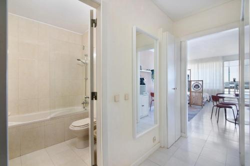 a white bathroom with a toilet and a tub at Algarve Vilamoura Apartment in Quarteira