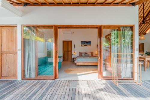 a room with sliding glass doors and a bedroom at Palm Paradise in Nusa Lembongan