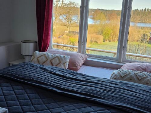 a bedroom with a bed and a window with a view at Anten Lake House in Alingsås