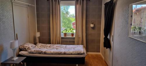 ein kleines Schlafzimmer mit einem Bett und einem Fenster in der Unterkunft Station 14 in Arvidsjaur