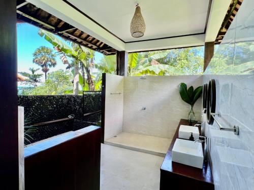 a bathroom with a tub and a sink and a shower at The Palms - Seraya Shores Retreat Bali in Seraya