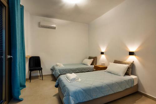 a room with two beds and a chair in it at Kaliva Villa in Kerames