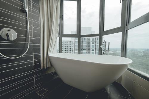 a white bath tub in a bathroom with a window at Teega Residence near Puteri Harbour Iskandar Puteri by Our Stay in Nusajaya