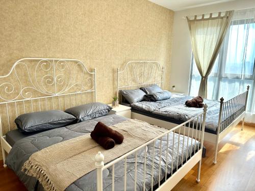a bedroom with two beds and a window at Teega Residence near Puteri Harbour Iskandar Puteri by Our Stay in Nusajaya