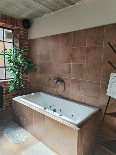 a bath tub in a bathroom with a brick wall at Hotel Na Vývoji in Vlašim