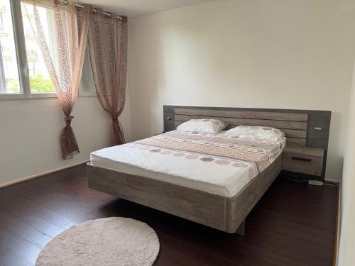 ein Schlafzimmer mit einem Bett, einem Fenster und einem Teppich in der Unterkunft Yara in Montargis