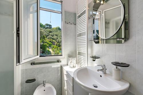 a white bathroom with a sink and a mirror at Ca' Da Giuvanna in Sestri Levante