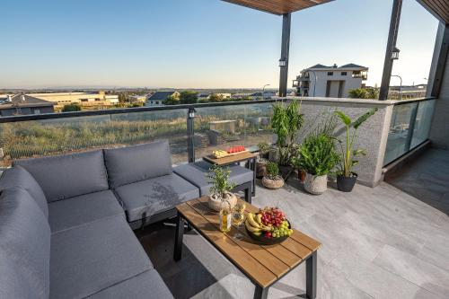 a living room with a couch and a table on a balcony at אחוזת אבישג - וילה יוקרתית עם בריכה מחוממת וממ"ד למשפחות in Shelomi