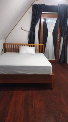 a bedroom with a bed with a window with curtains at Surf Logde katiet short motorcycle only minute from our places Bintang wave,Lance wave,HTs wave,monkeyWave in Katiet