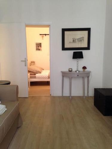 a living room with a table and a room with a bed at Apartment Limas in Avignon
