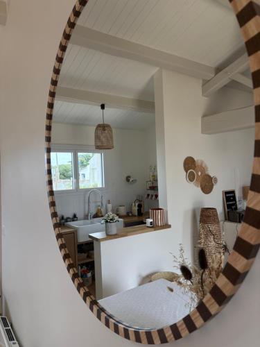 a mirror in a room with a kitchen at Hôtel Le Noirmoutier in Barbâtre