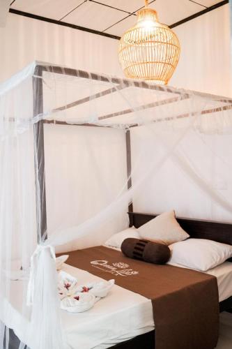 a bedroom with a bed and a chandelier at Ocean Life Ayurvedic Villa in Talalla South