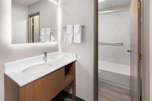 a bathroom with a sink and a bath tub at Days Inn by Wyndham Pierre in Pierre