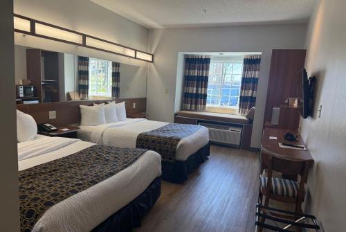 a hotel room with two beds and a window at Microtel Inn & Suites in Dickson City