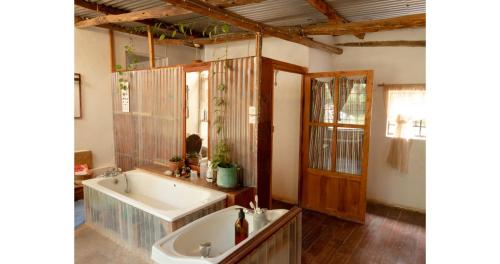 a bathroom with a tub and a sink and a mirror at Oloile - Home By The Park in Nairobi