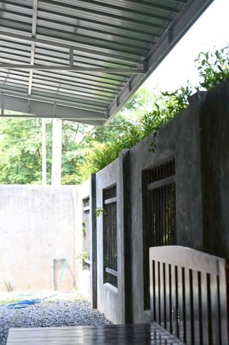 a patio with a table and a bench under awning at บ้านอิงฟ้าแม่ฮ่องสอน in Ban Mai Ngae
