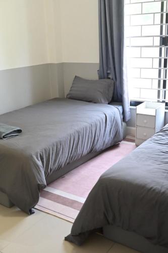 a bedroom with two beds and a window at บ้านอิงฟ้าแม่ฮ่องสอน in Ban Mai Ngae