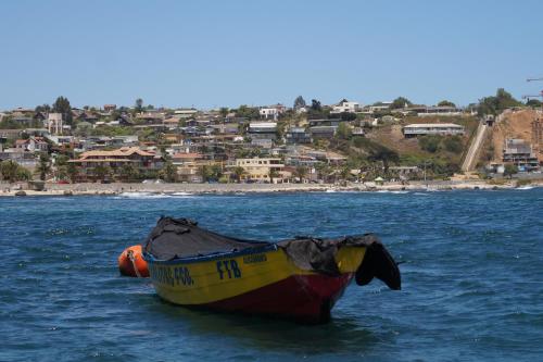 a yellow and red boat floating in the water at Kai Bed and Breakfast in Algarrobo
