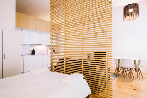 a bedroom with a white bed and a wooden wall at ORM - Ferreira Borges Apartment in Porto