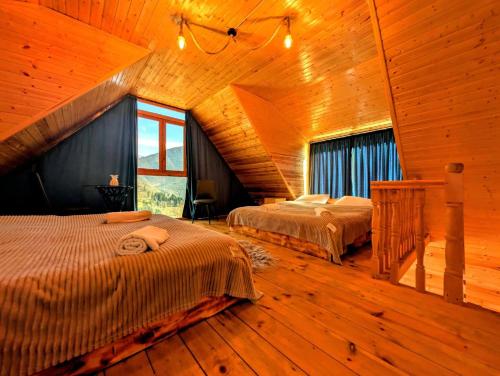 a bedroom with two beds in a wooden cabin at Cliffside - ქლიფსაიდი in Makhunts'et'i