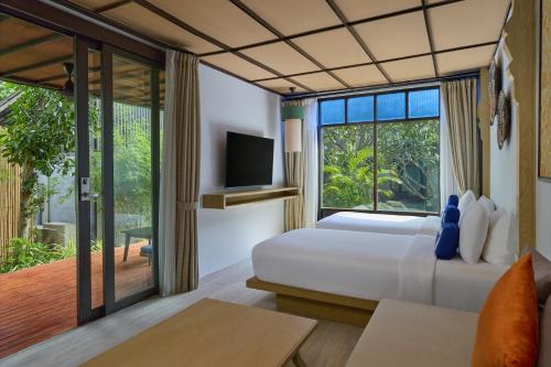 a bedroom with a bed and a large window at Homm Chura Samui in Chaweng