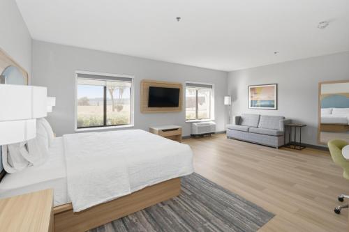 a white bedroom with a large bed and a couch at Hampton Inn & Suites Pharr in Pharr