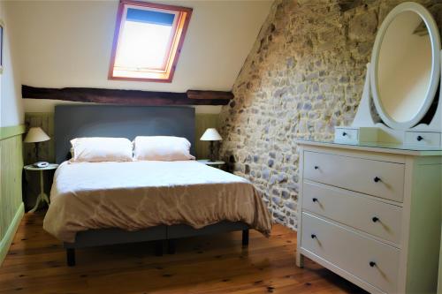 a bedroom with a bed with a mirror and a dresser at Grange Cottage - La Mare Chappey in Néhou