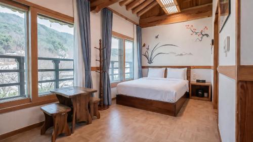 a bedroom with a bed and a large window at Jeonju Wangyijimil Hanok Hotel in Jeonju