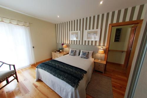 a bedroom with a bed and a striped wall at Estrela do Mar - Alojamento Local in Calheta