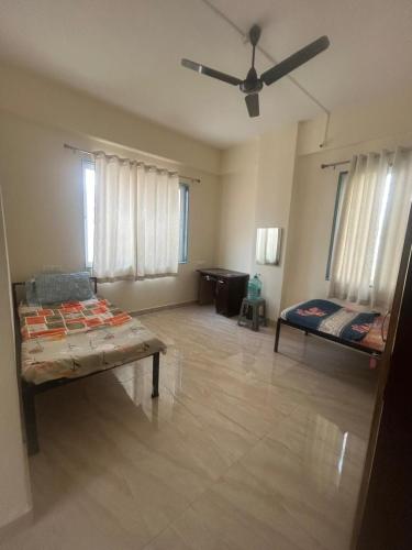 a living room with two beds and a ceiling fan at Peaceful & hygienic stay , Ideal for working professionals, Great for solo female travelers in Pune