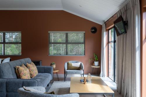 a living room with a couch and a table at Cape Dutch Stay, Suite B in Sedgefield