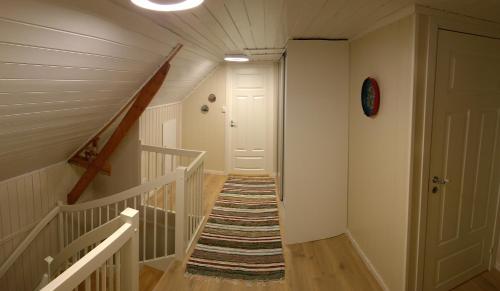 a hallway with a staircase leading to a door at Bustad in Larseng