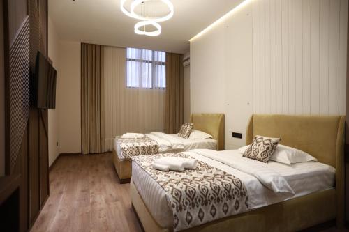 a hotel room with two beds and a television at Isra City Hotel in Dushanbe