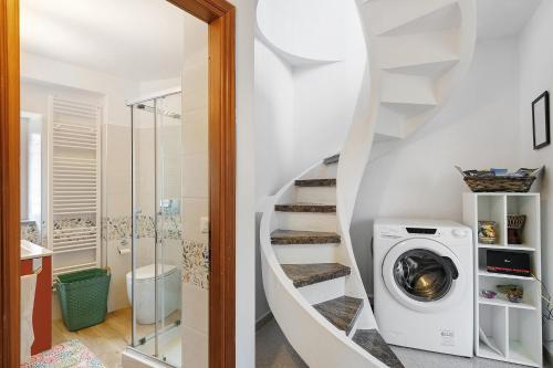 a bathroom with a washing machine next to a staircase at Casa Vacanze Il Primo Sole in Finale Ligure
