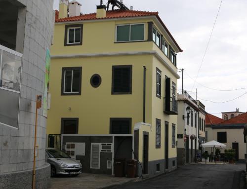a yellow building with a car parked in front of it at Apartamentos Sousa in Funchal