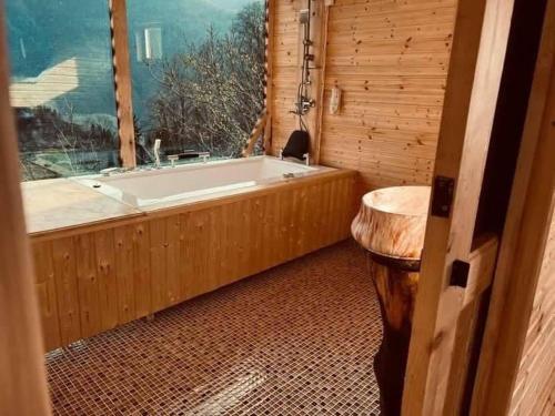 a bathroom with a tub and a sink and a window at Cliffside - ქლიფსაიდი in Makhunts'et'i