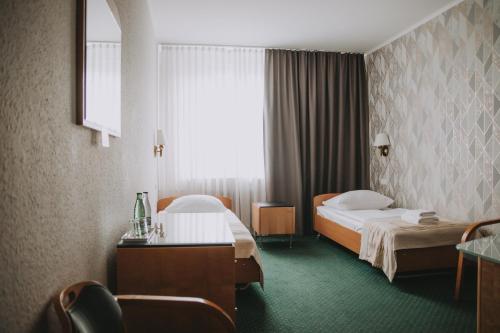 ein Hotelzimmer mit zwei Betten und einem Fenster in der Unterkunft Hotel Festival in Oppeln