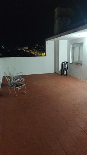 two chairs and a table on a roof at night at Edén in La Falda