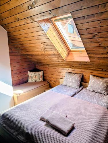 a room with two beds in a wooden cabin at Rose Hip Hill Farm in Valea Tîrnei
