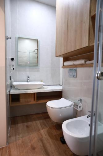 a bathroom with a toilet and a sink and a mirror at Isra City Hotel in Dushanbe