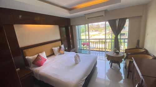 a hotel room with a bed and a balcony at Sota Residence in Pattaya South