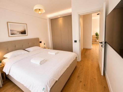 a bedroom with a large bed with white sheets at Da Vinci Luxury Home Otopeni in Otopeni