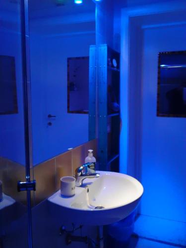 a bathroom with a white sink and a mirror at La Casa di Ulisse B&B in Quercianella