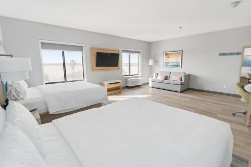 a white room with two beds and a flat screen tv at Hampton Inn & Suites Pharr in Pharr