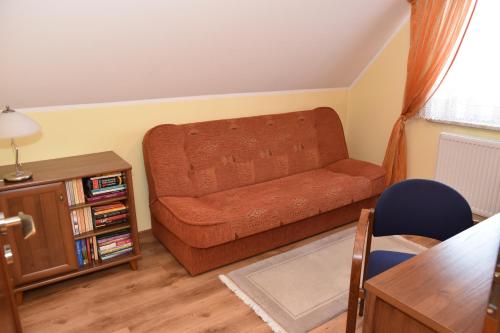 a living room with a couch and a table at Dom z widokiem na jezioro i domek nad jeziorem in Łapalice