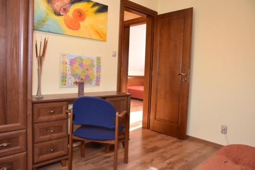 a room with a desk and a blue chair at Dom z widokiem na jezioro i domek nad jeziorem in Łapalice