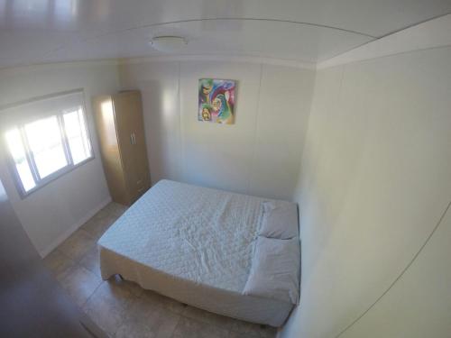 1 dormitorio con 1 cama en la esquina de una habitación en Apartamentos Titilandia, en Piriápolis